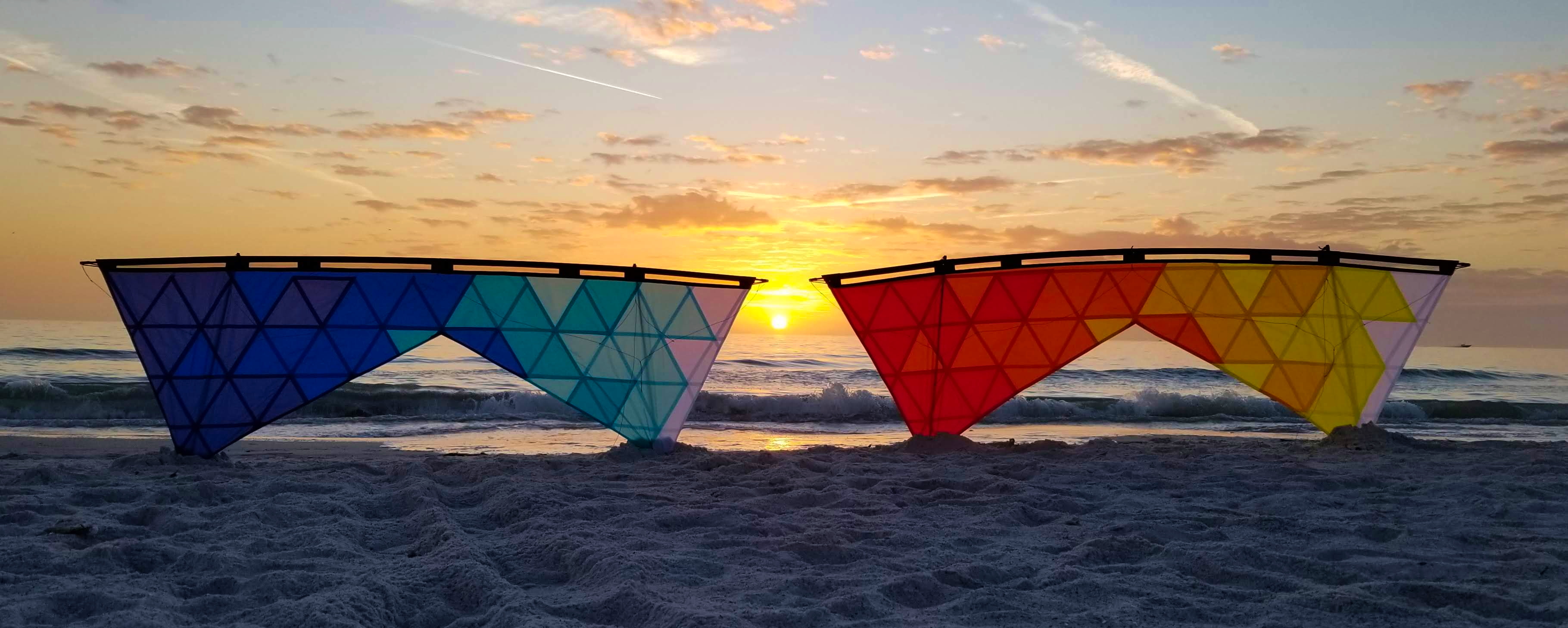 Mosaic sport kites on a beach at sunset